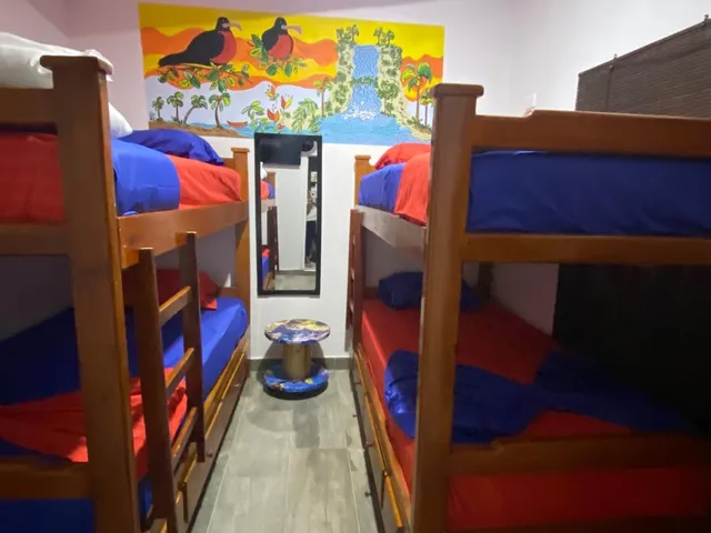 Camarotes con ropa de cama azul y roja en la habitación Currulao